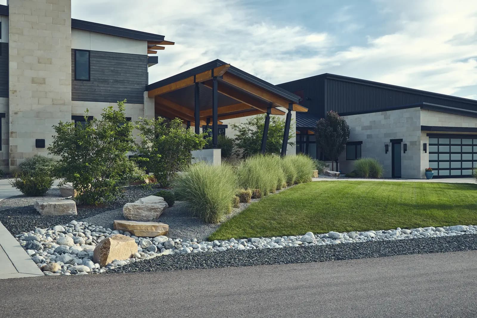 Covered patio corner with ornamental grasses, boulders, and river rock beds, Colorado