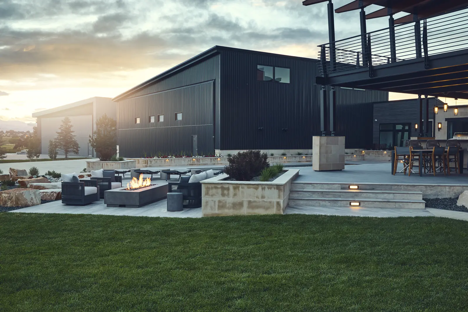 Lawn and fire pit lounge in front of a modern Colorado home at sunset