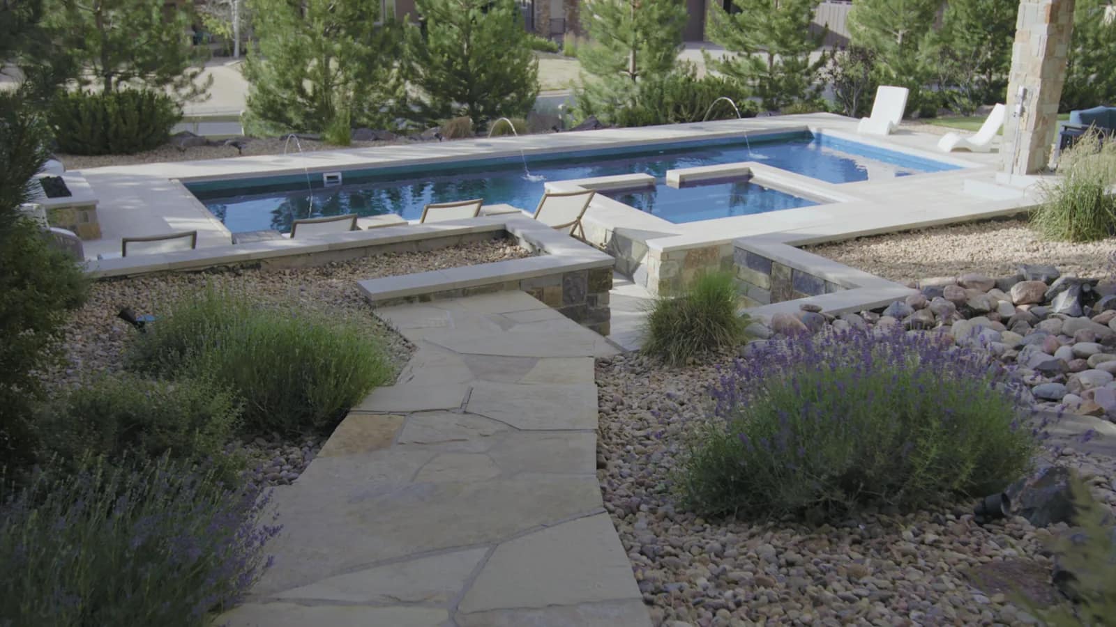 Custom pool with laminar deck jets and raised spa at twilight, Zamucen Residence in Colorado