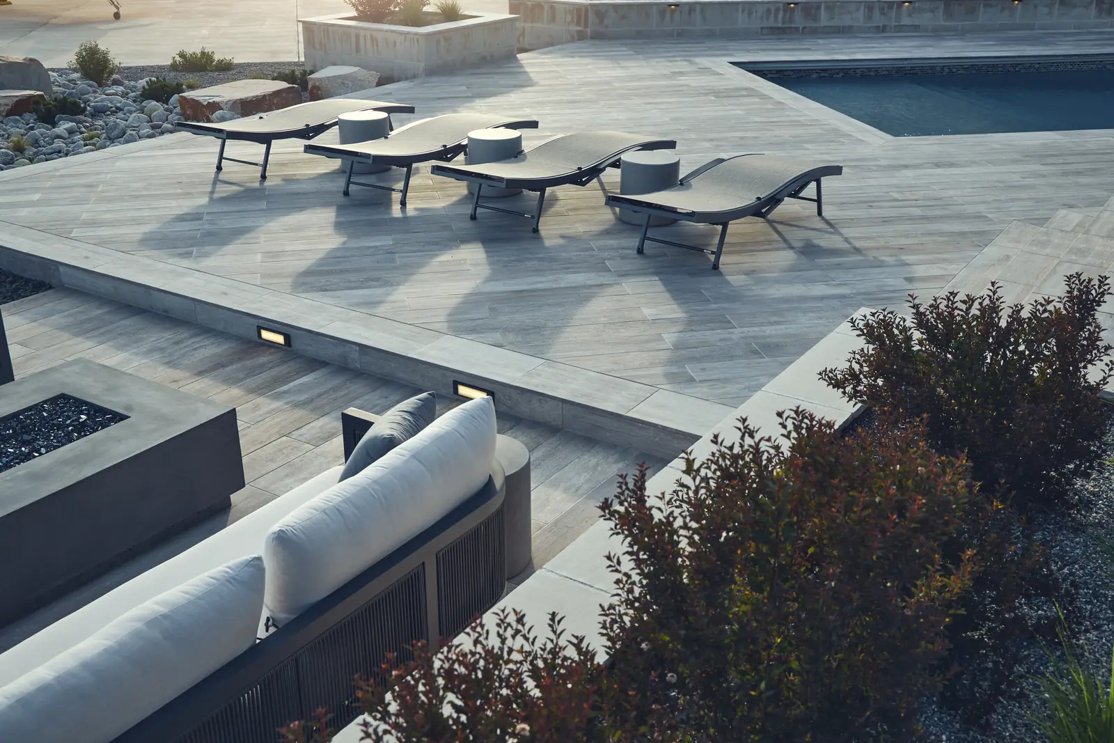 Elevated view of a porcelain paver deck, chaise lounges, pool corner, and sunken lounge, Colorado
