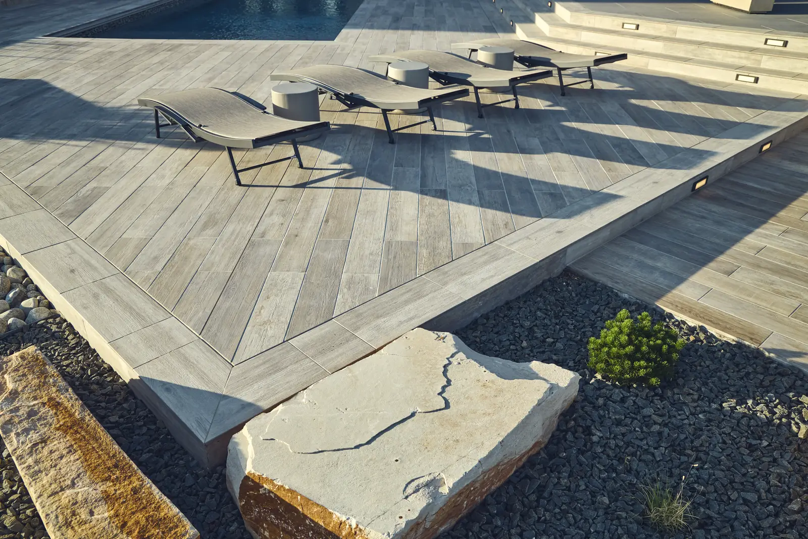 Deck corner with diagonal porcelain pavers, a large stone slab, and boulder accents, Colorado