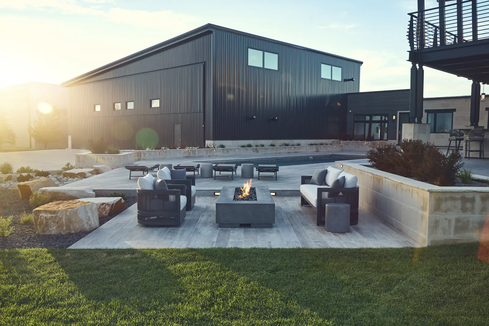 Sunset over the sunken fire lounge with sofas and the hangar in the background